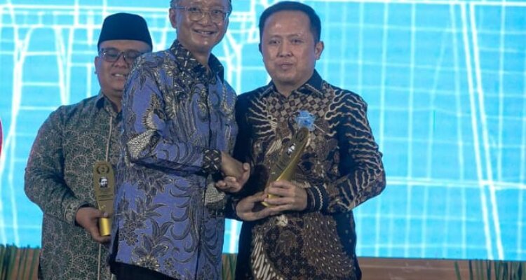 Menteri Pekerjaan Umum, Dedy Hanggodo menyerahan penghargaan kepada Pemda Haltim yang diwakili oleh Kadis PUPR Haltim, Rivolino Merbas.